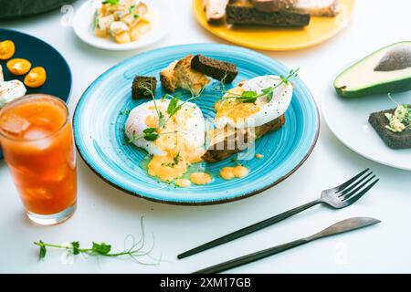 Eier, Benedikt auf Brot Toast und Avocado auf einer Scheibe Roggenbrot, Käse und ein Glas Orangensaft auf dem Tisch. Ausgewählter Fokus. Hochwertige Fotos Stockfoto