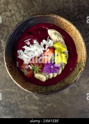Smoothie Schüssel mit Bananen, Erdbeeren und Kokosflocken, wunderschön dekoriert. Stockfoto