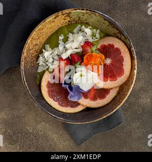 Matcha Smoothie Schüssel mit Orangen-, Erdbeeren- und Kokosflocken, wunderschön dekoriert. Stockfoto