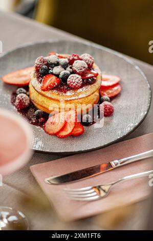 Hausgemachte, flauschige Pfannkuchen mit Obst und Marmelade auf der Oberseite. Stockfoto