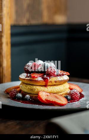 Hausgemachte, flauschige Pfannkuchen mit Obst und Marmelade auf der Oberseite. Stockfoto