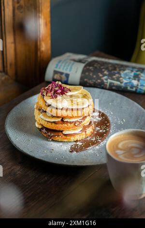 Hausgemachter, flauschiger Bananenpfannkuchen mit Schokolade auf einem Coffee-Shop-Tisch. Stockfoto