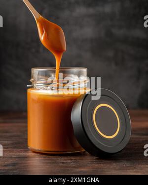 Erdnuss, Mandel, Nussbutter, Glas offen, mit einem Löffel die Butter mischen Stockfoto