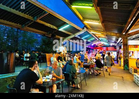 Menschen essen auf dem Open-Air-Markt Nocny Market (Nachtmarkt) auf den ehemaligen Bahnsteigen des Hauptbahnhofs in Warschau, Polen Stockfoto