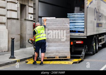 London, England, Großbritannien - 27. Juni 2023: LKW-Fahrer entladen eine Palette von Gütern vom Heck eines Lkws mit einem Aufzug und Wagen im Zentrum von London. Stockfoto