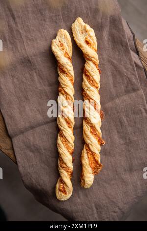 Hausgemachter Käsestab auf einer Leinentischdecke. Stockfoto