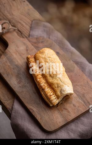 Vegane Wurstrolle auf einem hölzernen Schneidebrett. Draufsicht. Stockfoto