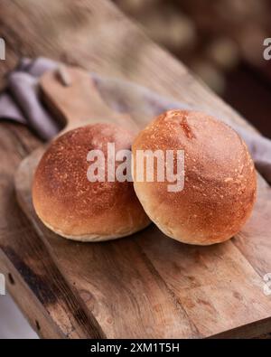 Hausgemachte Brötchen auf Schneidebrett auf einer Holzbank. Draufsicht Stockfoto