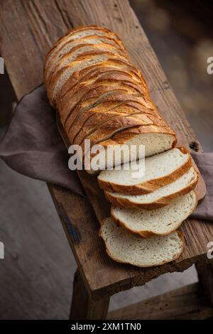 Frisches, hausgemachtes Brot, geschnitten auf einem rustikalen Holztisch. Draufsicht Stockfoto