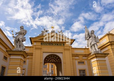 Melk, Österreich - 25. Oktober 2023 : Ein gelber Bogengang mit Statuen auf beiden Seiten und die Inschrift „Anno MDCCXVIII“ oben. Der Bogengang führt zu einem c Stockfoto