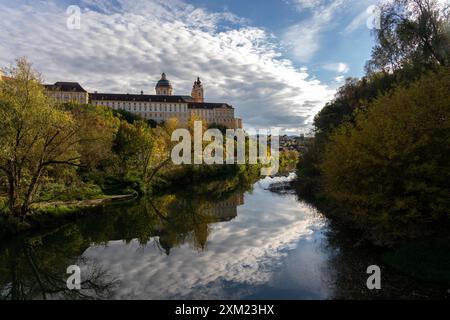 Melk, Österreich - 25. Oktober 2023 : Ein malerischer Blick auf ein großes Gebäude, das sich im ruhigen Wasser eines Flusses in Melk, Österreich, spiegelt. Stockfoto