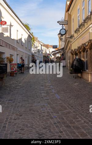 Melk, Österreich - 25. Oktober 2023 : Kopfsteinpflasterstraße in Melk, Österreich, mit Geschäften und ein paar Fußgängern. Stockfoto