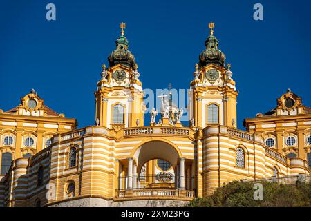 Melk, Österreich - 25. Oktober 2023 : Ein gelb-weiß gestreiftes Kloster in Melk, Österreich mit komplizierten Details und blauem Himmel. Stockfoto