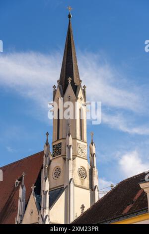 Melk, Österreich - 25. Oktober 2023 : Ein Kirchturm mit zwei Uhren vor einem blauen Himmel in Melk, Österreich. Stockfoto