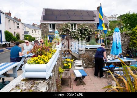 Menschen, die im Sommer 2024 im Pub-Garten an Picknicktischen sitzen, essen und trinken Little Haven Pembrokeshire Wales UK KATHY DEWITT Stockfoto