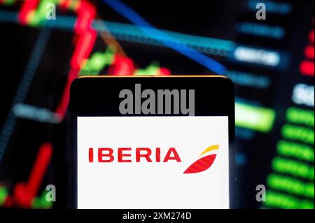 China. Juli 2024. In dieser Fotoabbildung wird das Logo der spanischen Fluggesellschaft Iberia auf einem Smartphone mit einem wirtschaftlichen Börsenindex im Hintergrund angezeigt. Quelle: SOPA Images Limited/Alamy Live News Stockfoto