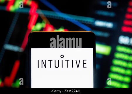 China. Juli 2024. In dieser Fotoabbildung zeigt das amerikanische Unternehmen, das chirurgische Roboterprodukte entwickelt und herstellt intuitive Chirurgie (NASDAQ: ISRG) Logo, das auf einem Smartphone mit einem wirtschaftlichen Börsenindex-Diagramm im Hintergrund zu sehen ist. Quelle: SOPA Images Limited/Alamy Live News Stockfoto