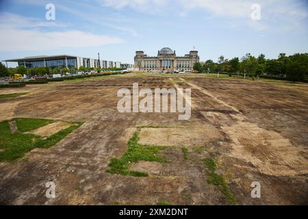 Berlin, Deutschland. Juli 2024. Blick auf den stark beschädigten Rasen vor dem Reichstagsgebäude. Nachdem die Fächerzone der Europameisterschaft abgebaut wurde, befindet sich der Rasen in einem sehr schlechten Zustand. Quelle: Jörg Carstensen/dpa/Alamy Live News Stockfoto