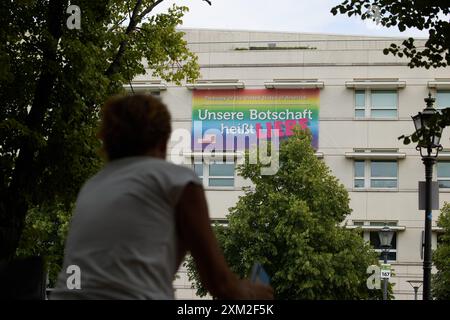 Berlin, Deutschland. Juli 2024. Zum Christopher Street Day (CSD) an diesem Wochenende wurde eine Regenbogenfahne mit den Worten „unsere Botschaft ist Liebe“ auf der US-Botschaft in der Ebertstraße platziert. Quelle: Jörg Carstensen/dpa/Alamy Live News Stockfoto