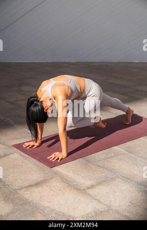 Eine brünette Frau in Sportbekleidung in Yoga-Pose Stockfoto