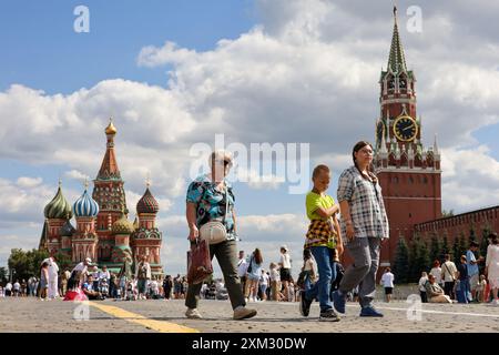 Im Sommer laufen die Leute auf dem Roten Platz in Moskau. Blick auf die Basilius-Kathedrale und Touristen Stockfoto