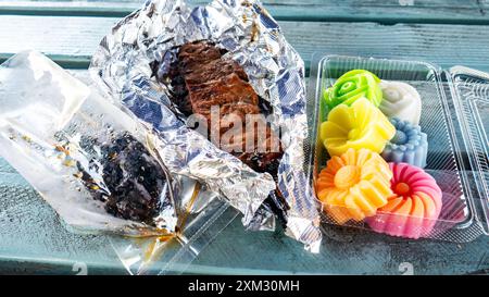 Hühnerleberspieße, gegrillte Rindfleischspieße, Kokosmilchgelee (wun kathi) auf einem thailändischen Lebensmittelmarkt in LA, Kalifornien. Traditionelles thailändisches Street Food Stockfoto