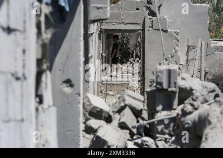 Khan Yunis, Palästinensische Gebiete. Juli 2024. Ein palästinensisches Kind spaziert zwischen den Überresten eines zerstörten Gebäudes nach einem israelischen Luftangriff auf Khan Younis. Abed Rahim Khatib/dpa/Alamy Live News Stockfoto
