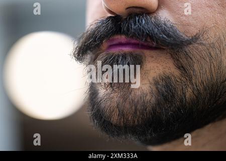 Berlin, Deutschland. Juli 2024. Ein Mann trägt lila Lippenstift. Der 29. Juli ist der Lippenstifttag. Quelle: Hannes P. Albert/dpa/Alamy Live News Stockfoto