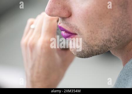 Berlin, Deutschland. Juli 2024. Ein Mann trägt lila Lippenstift. Der 29. Juli ist der Lippenstifttag. Quelle: Hannes P. Albert/dpa/Alamy Live News Stockfoto