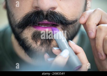 Berlin, Deutschland. Juli 2024. Ein Mann hat lila Lippenstift aufgetragen. Der 29. Juli ist der Lippenstifttag. Quelle: Hannes P. Albert/dpa/Alamy Live News Stockfoto
