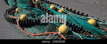 Detail eines bunten großen Fischernetzes, das im Hafen von Hirtshals, Dänemark, trocknet. Stockfoto