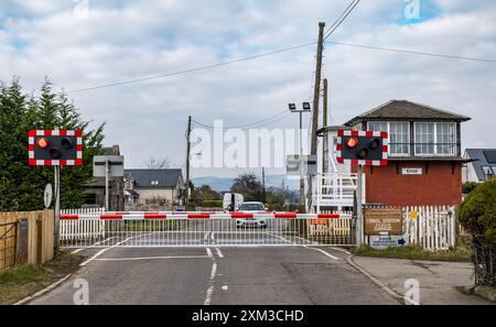 Barrieren und blinkende rote Warnleuchte am Bahnübergang, Errol Station, Perthshire, Schottland, Großbritannien Stockfoto