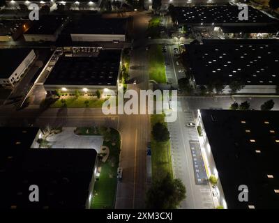 Mehrere Lagergebäude in einem Industriepark werden spät in der Nacht aus der Luft gezeigt. Stockfoto