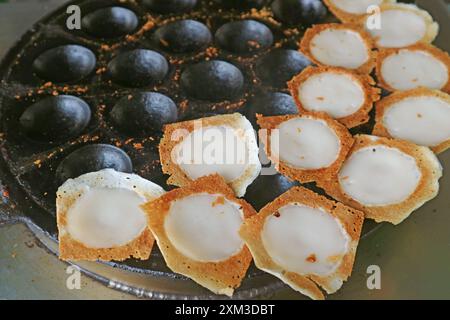 Frisch gekochte Kanom Krok, thailändische Kokosnussmilchpfannkuchen, die knusprig sind und innen cremig sind Stockfoto