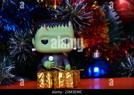 Funko Pop Actionfigur der beliebten Horror-fiktionalen Figur Frankensteins Monster. Weihnachtsbaum, helle Ornamente, goldene Geschenkboxen, Feiertage. Stockfoto