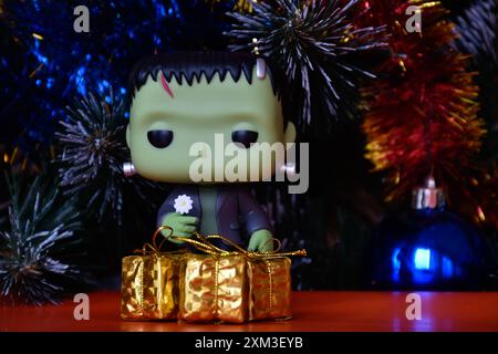 Funko Pop Actionfigur der beliebten Horror-fiktionalen Figur Frankensteins Monster. Weihnachtsbaum, helle Ornamente, goldene Geschenkboxen, Feiertage. Stockfoto