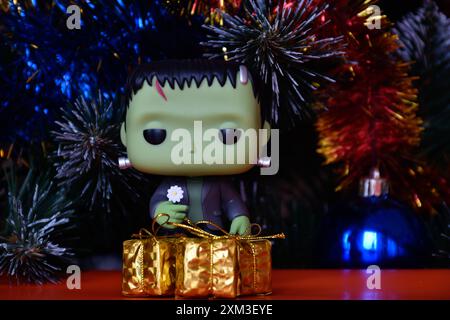 Funko Pop Actionfigur der beliebten Horror-fiktionalen Figur Frankensteins Monster. Weihnachtsbaum, helle Ornamente, goldene Geschenkboxen, Feiertage. Stockfoto