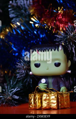 Funko Pop Actionfigur der beliebten Horror-fiktionalen Figur Frankensteins Monster. Weihnachtsbaum, helle Ornamente, goldene Geschenkboxen, Feiertage. Stockfoto