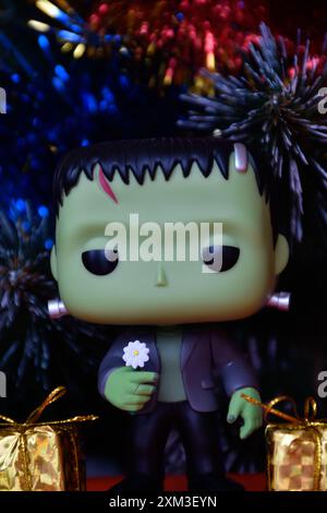 Funko Pop Actionfigur der beliebten Horror-fiktionalen Figur Frankensteins Monster. Weihnachtsbaum, helle Ornamente, goldene Geschenkboxen, Feiertage. Stockfoto