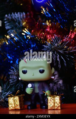 Funko Pop Actionfigur der beliebten Horror-fiktionalen Figur Frankensteins Monster. Weihnachtsbaum, helle Ornamente, goldene Geschenkboxen, Feiertage. Stockfoto