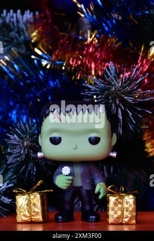 Funko Pop Actionfigur der beliebten Horror-fiktionalen Figur Frankensteins Monster. Weihnachtsbaum, helle Ornamente, goldene Geschenkboxen, Feiertage. Stockfoto