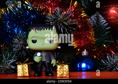 Funko Pop Actionfigur der beliebten Horror-fiktionalen Figur Frankensteins Monster. Weihnachtsbaum, helle Ornamente, goldene Geschenkboxen, Feiertage. Stockfoto