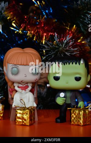 Funko Pop Actionfiguren von Horrorfiguren spukten der Puppe Annabelle und Frankensteins Monster. Weihnachtsbaum, goldene Geschenkboxen, Girlande, Ornamente. Stockfoto