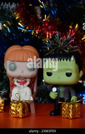 Funko Pop Actionfiguren von Horrorfiguren spukten der Puppe Annabelle und Frankensteins Monster. Weihnachtsbaum, goldene Geschenkboxen, Girlande, Ornamente. Stockfoto