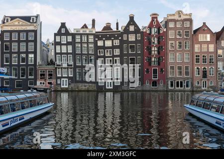 Ein klassischer Blick auf eine Reihe alter traditioneller Amsterdamer Häuser im Damrak im Zentrum von Amsterdam. Stockfoto