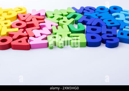 Bunte Buchstaben Bausteine zufällig verstreut auf weißem Hintergrund Stockfoto