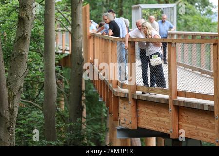 Nürnberg, Deutschland. Juli 2024. Elfriede und Klaus aus Schnaittach blicken vom Baumkronensteg im Zoo herunter. Ab Freitag können Besucher des Zoos über einen 450 Meter langen und 2,5 Meter breiten Holzsteg in bis zu 20 Meter Höhe spazieren. Die Brückenkonstruktion, die als „Klimawaldpfad“ konzipiert ist, ermöglicht es, den Wald auf spielerische Weise zu erleben und ist auch mit Kinderwagen und Rollstühlen erreichbar. Darlegung: Daniel Löb/dpa/Alamy Live News Stockfoto
