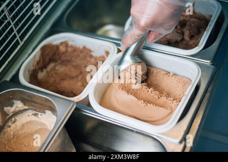 Der Verkäufer legt eine Kugel Eiscreme-Schaufel Stockfoto