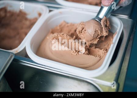 Der Verkäufer legt eine Kugel Eiscreme-Schaufel Stockfoto