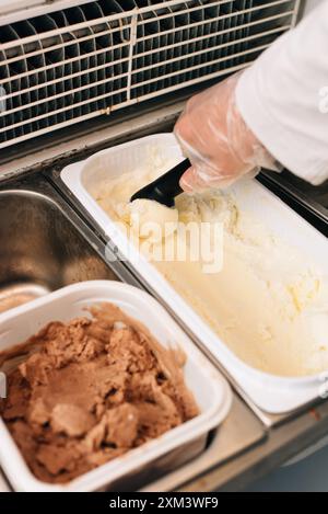 Der Verkäufer legt eine Kugel Eiscreme-Schaufel Stockfoto
